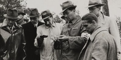Presentation to Józef Mackiewicz (inside in a light coat) of documents regarding the victims of the Soviet crime in Katyn (1943)